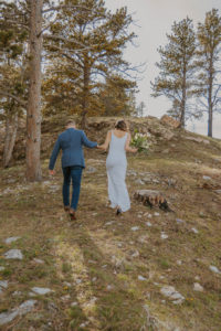 bride and groom hiking up a mountain for elopement ceremony