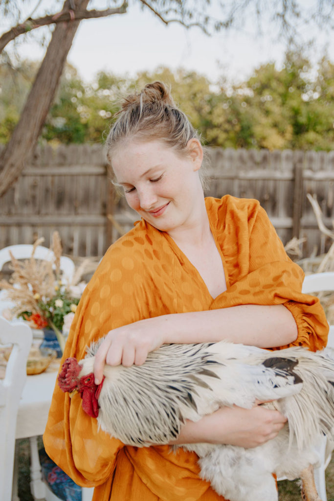 Morgan Holds a Chicken Before Fall Harvest Dinner