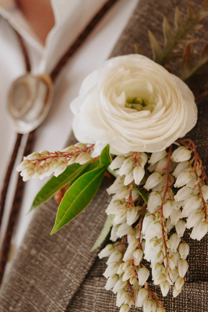 white boutonniere for groom for winter wedding