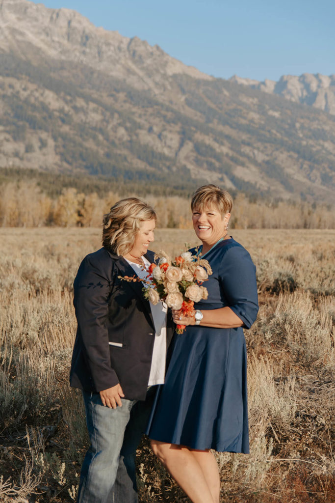 Beth and Haley Smile with Tetons in Background of Wyoming Destination Elopement