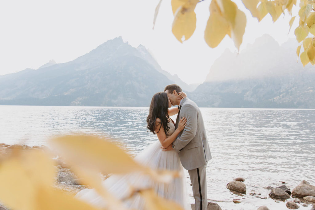 Couple Kisses with Tetons In Background