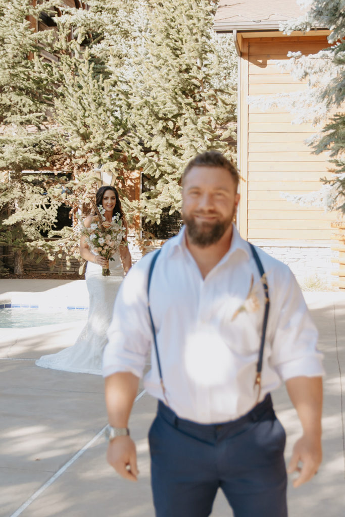 Bride walking up behind groom during first look photos in jackson Hole