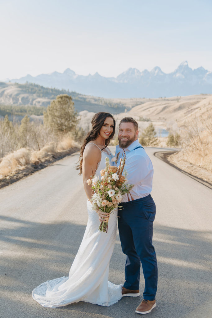 Couple smiling during wedding photography in front of the Tetons by the wedding tree