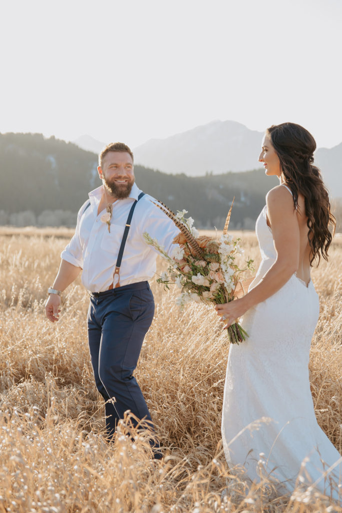 Moulton barn wedding sunset photos of couple walking in grass holding hands