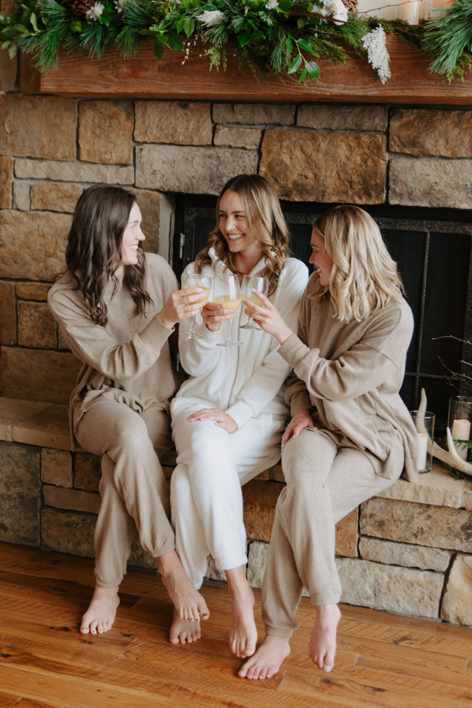 The bride ad her two sisters toasting in their loungewear before the ceremony
