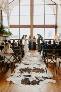a Wide view of the ceremony venue with rustic details and cowhide rug