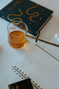 whiskey glass sits beside planner