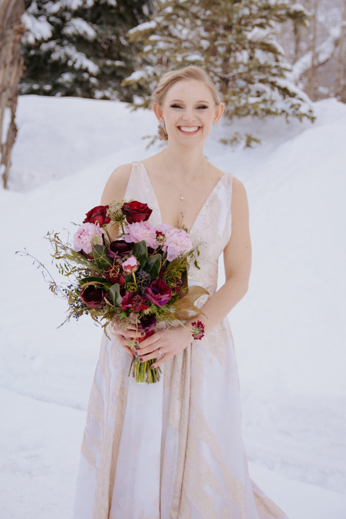 Winter bride holds her bouquet from her Wyoming elopement package