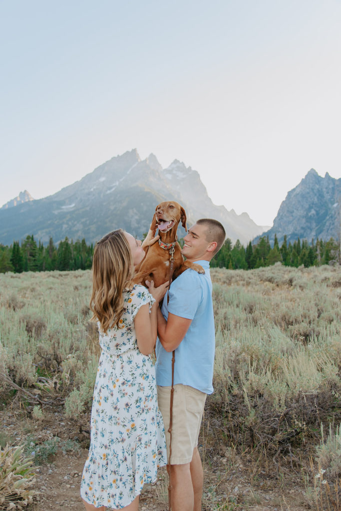 Ariane & Jackson candid engagement photo with their dog in a gorgeous field