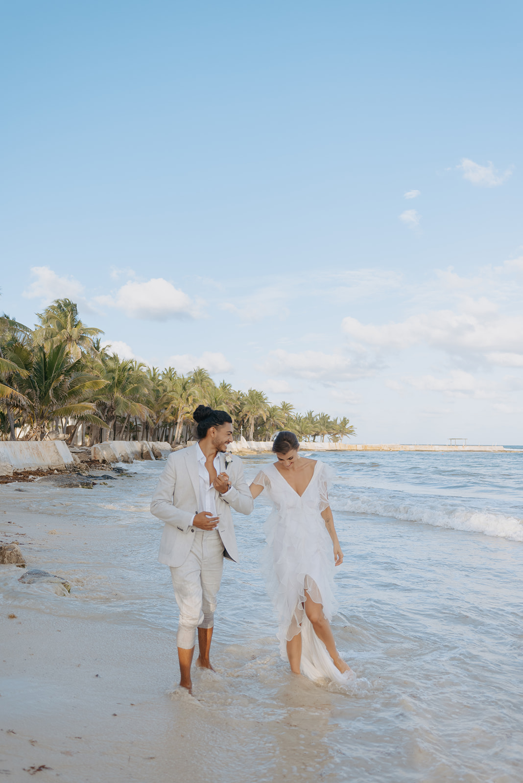 Couple walking on on Playa Del Carmen Beach after their destination wedding