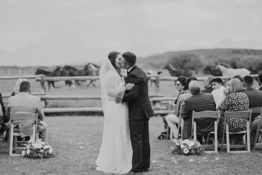 Bride and groom kiss during wedding ceremony at Diamond Cross ranch. 