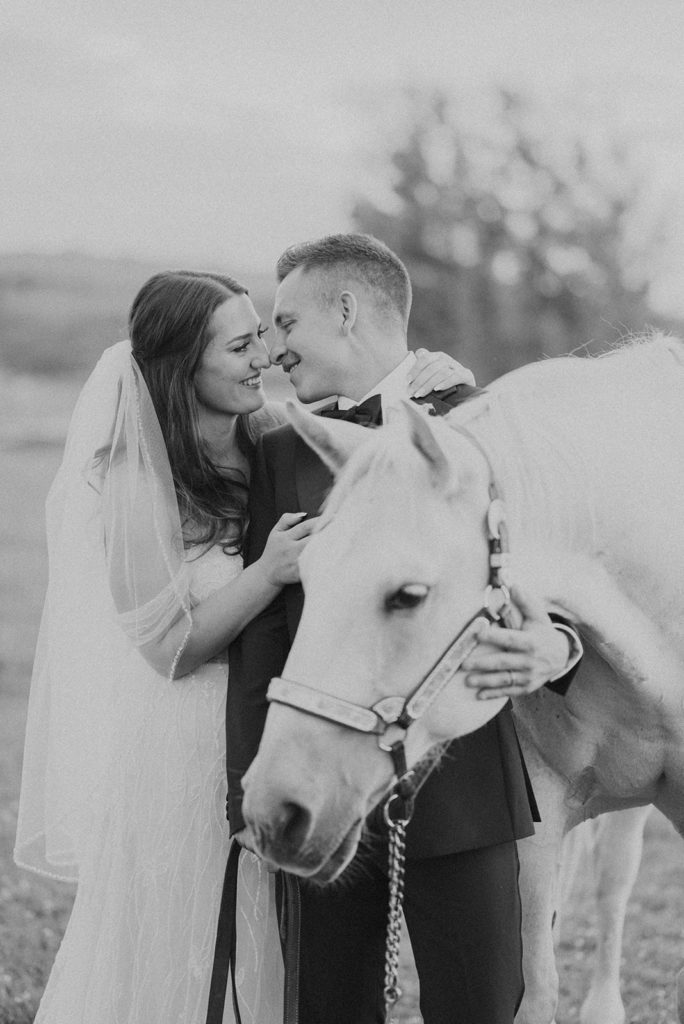 Bride and groom photo ops with white horse at Diamond Cross ranch. 