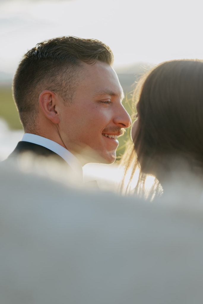 Groom smiling at bride during Diamond Cross ranch ceremony 