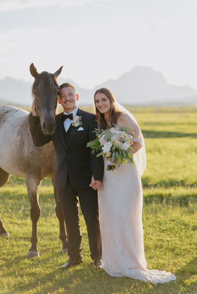 Newlyweds posing next to horses from Diamond Cross ranch. 