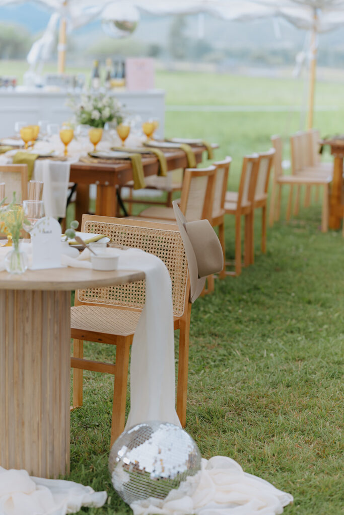 Cowboy Disco! A sweet heart table at a diamond cross ranch wedding with a disco ball and cowboy hat adorning the grooms chair 